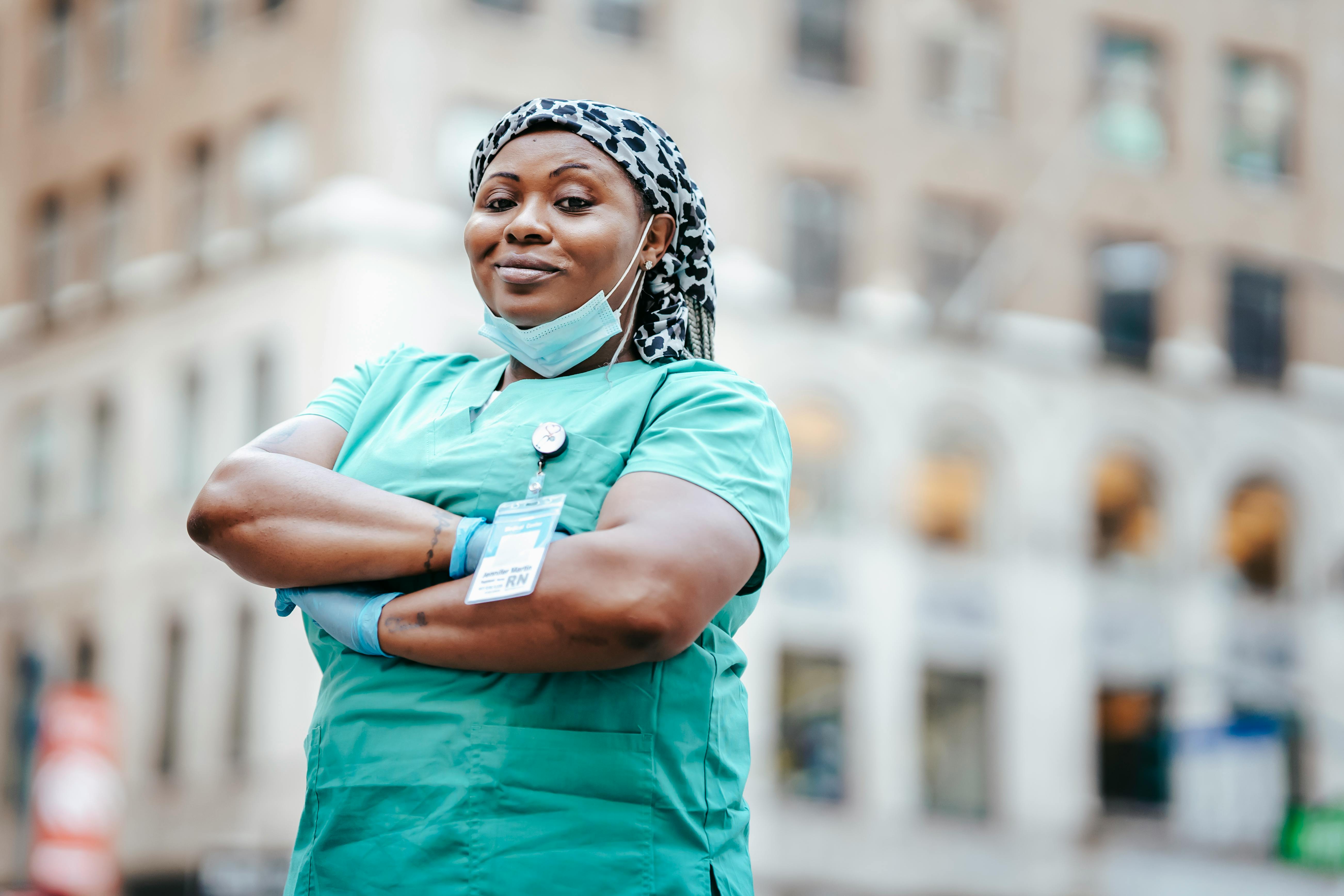 A frontline healthcare worker in scrubs and an ID badge — the people RedeApp is built for.